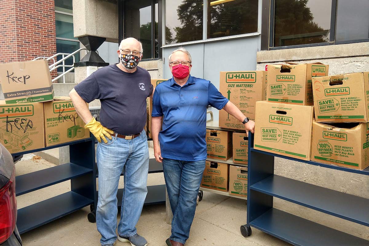 two people standing in front of boxes 