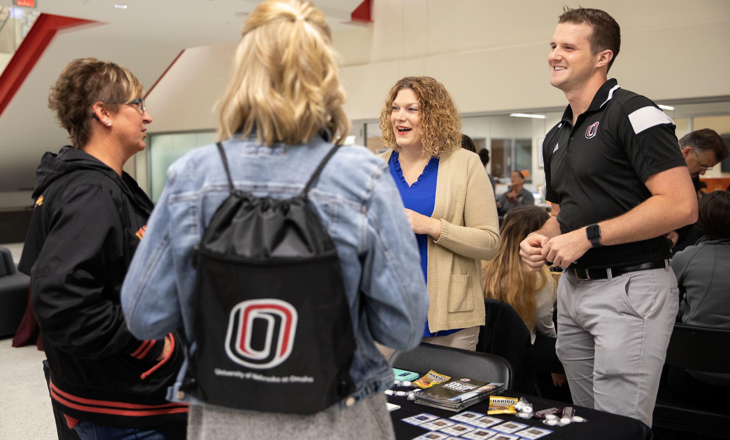 Assistant Director Kelly Malone and Counselor Colton Janes at a table discussing Dual Enrollment to guests.