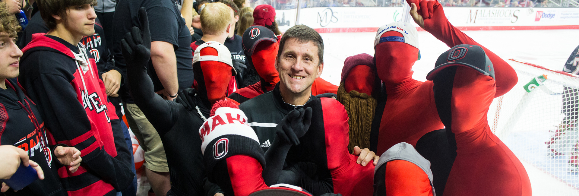 NU President Hank Bounds poses for a photo with the Maverick Maniacs in Baxter Arena's student section.