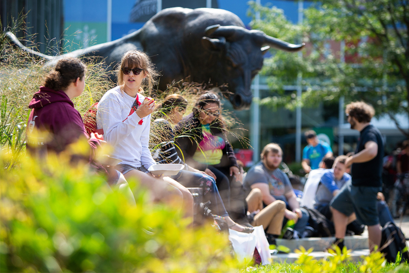 Students enjoy the weather in front of the Maverick Monument during UNO's first week of the fall semester.