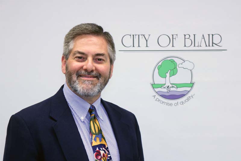 Phil Green, MPA alumnus, in front of the city seal for Blair, Neb.