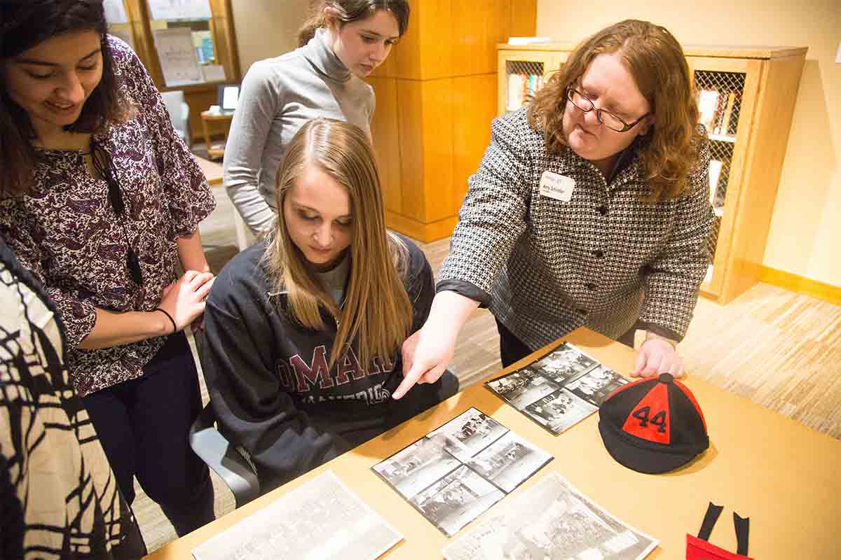 Students and UNO archivists examine materials kept within the Criss Library Archives & Special Collections