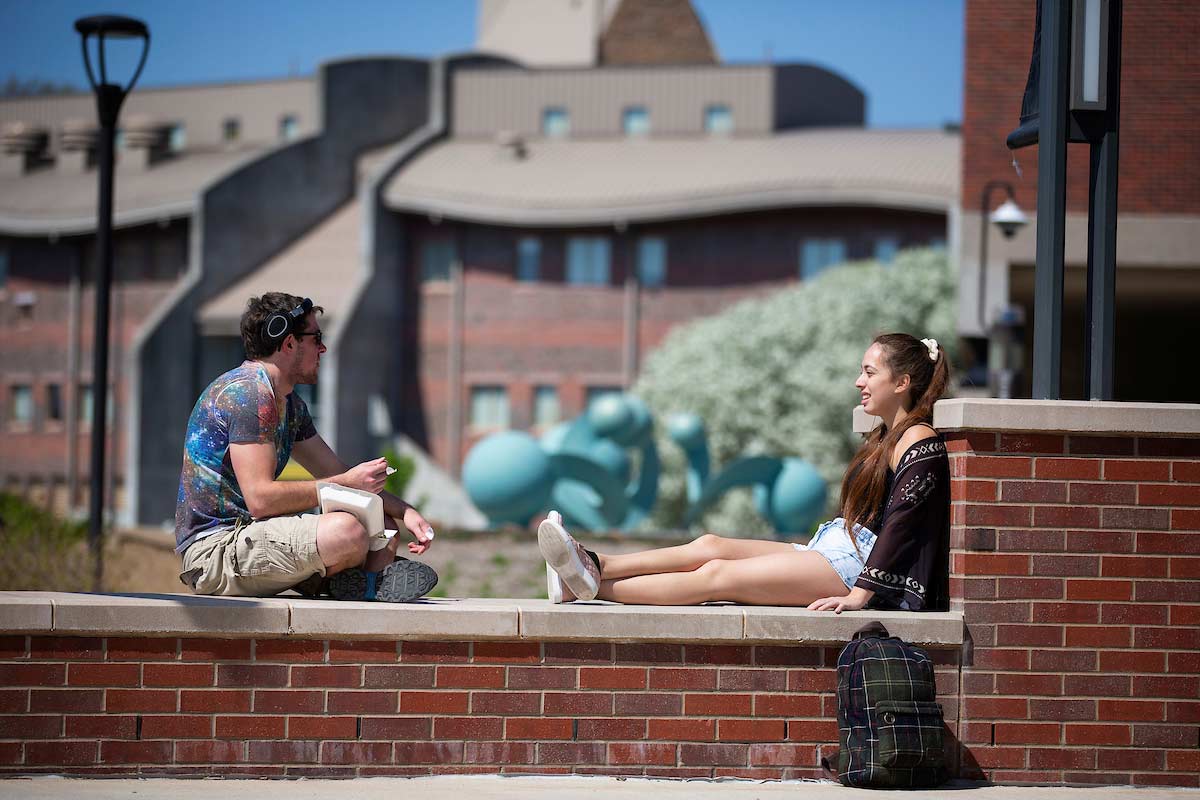 Two students having a conversation by the Henningson Plaza on UNO's Dodge Campus
