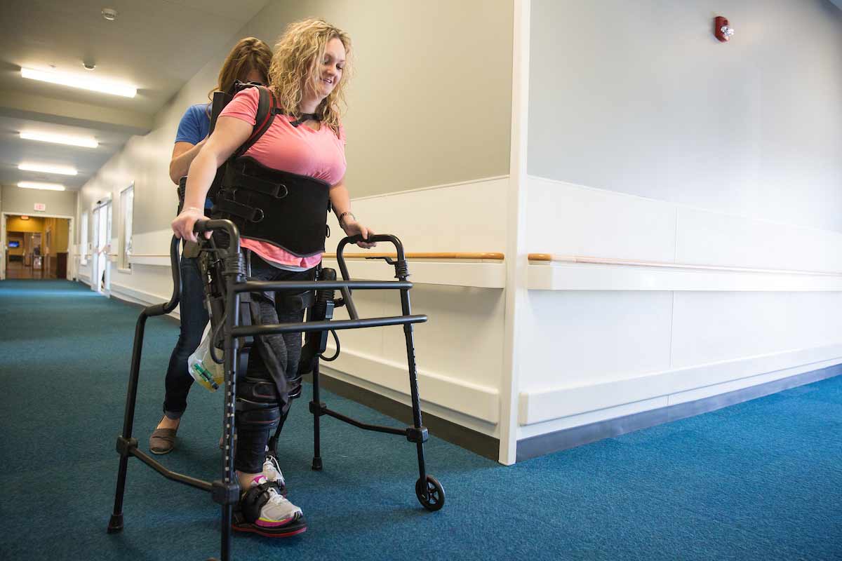 Schaaf walks down the hallways at QLI in her exoskeleton. 