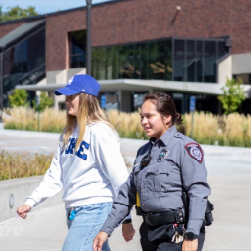 Campus security officer walking a student across campus