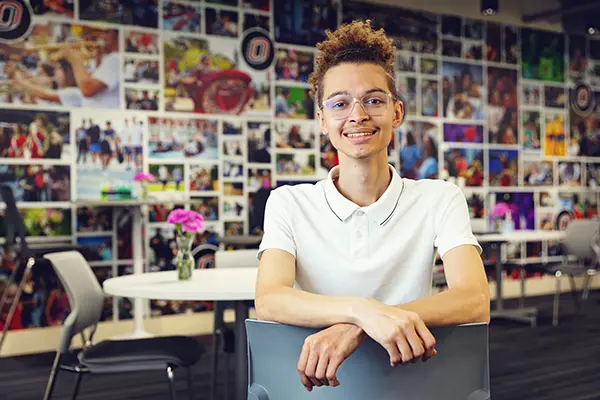 Dylan Clute sitting in front of a collage of images