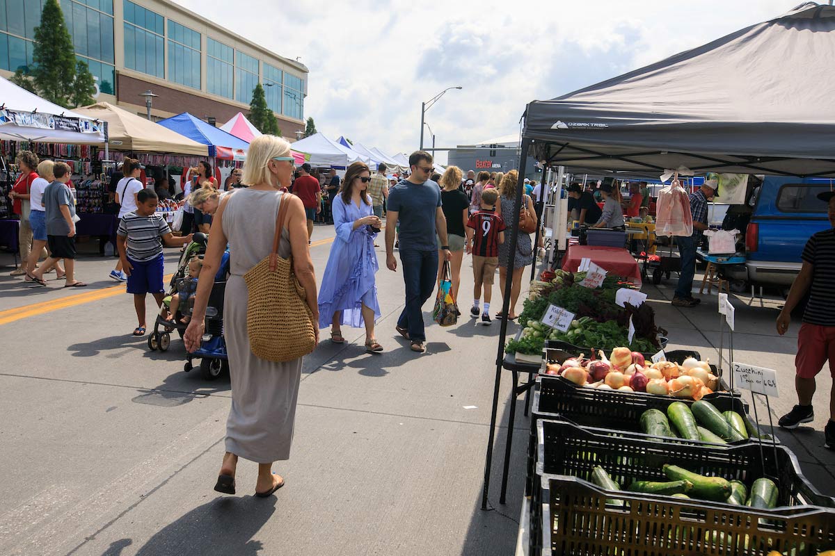 Visitors walk around the Aksarben Village Farmers Market