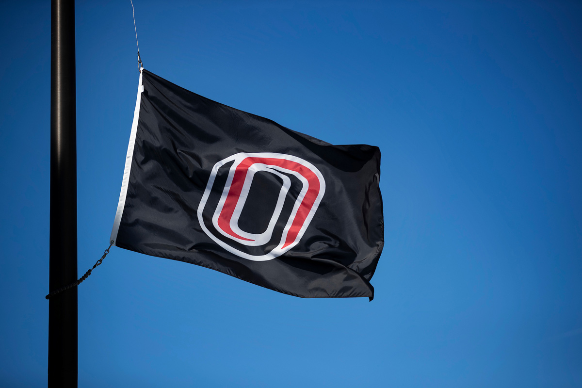 A UNO "O" flag blows in the wind on a clear day.