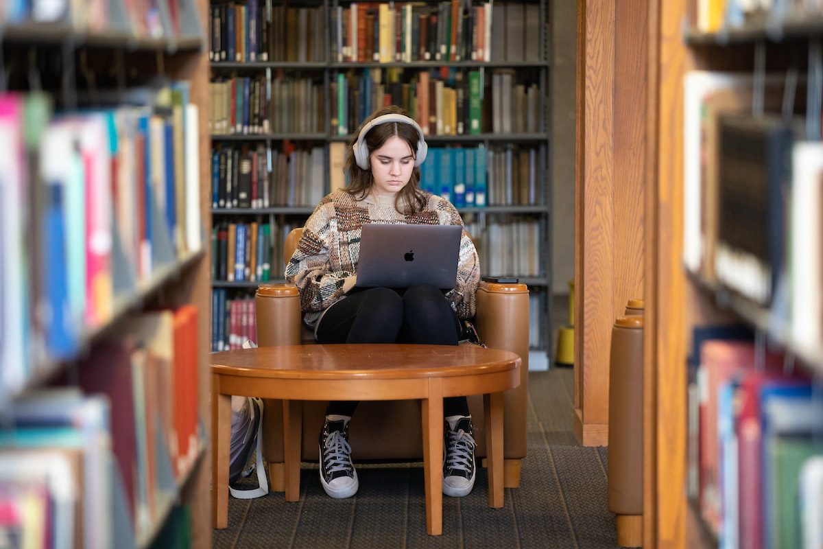 student studying on a laptop in library