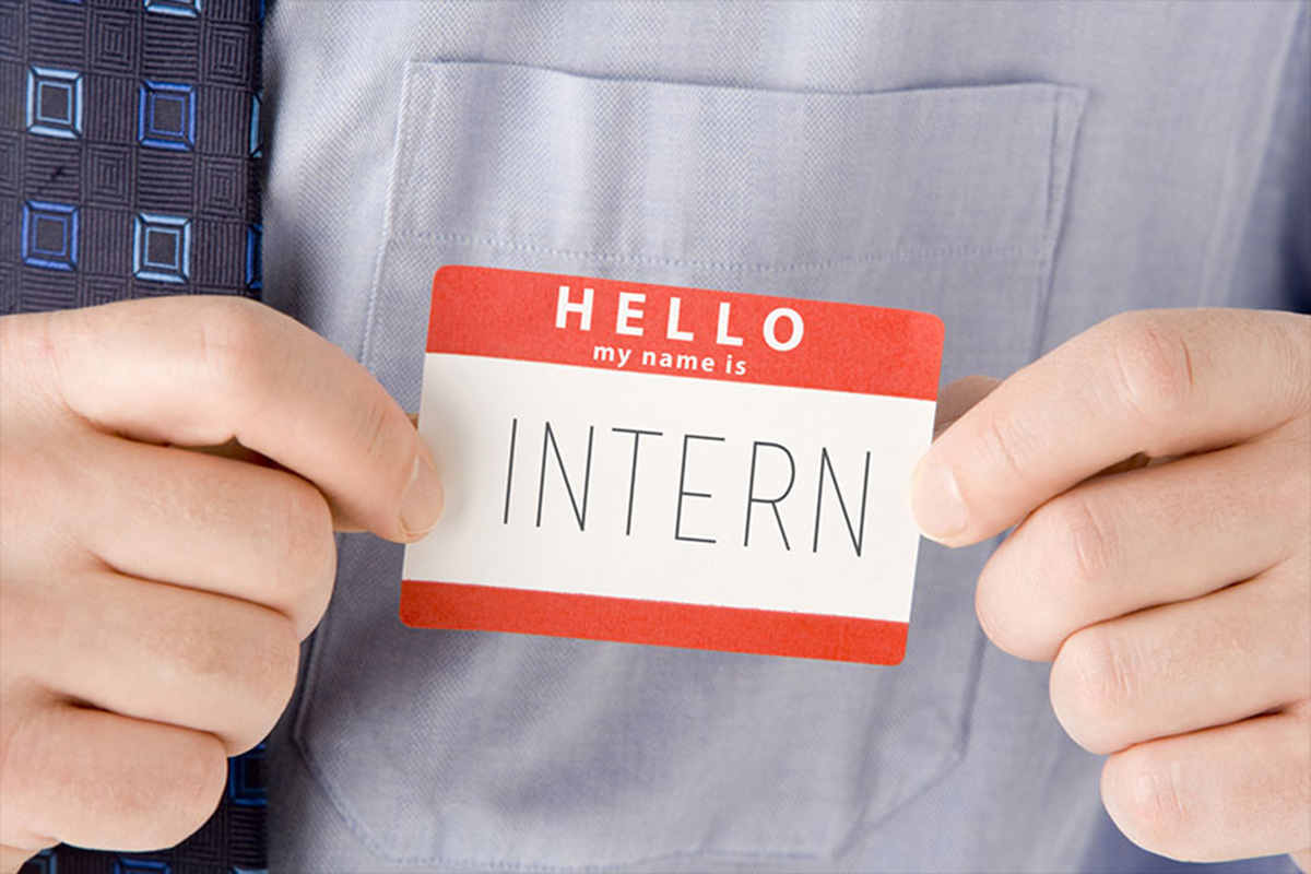 Close-up of someone with a nametag on that says hello my name is intern.