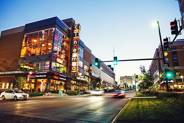 Cars and pedestrians move through the Old Market district at dusk
