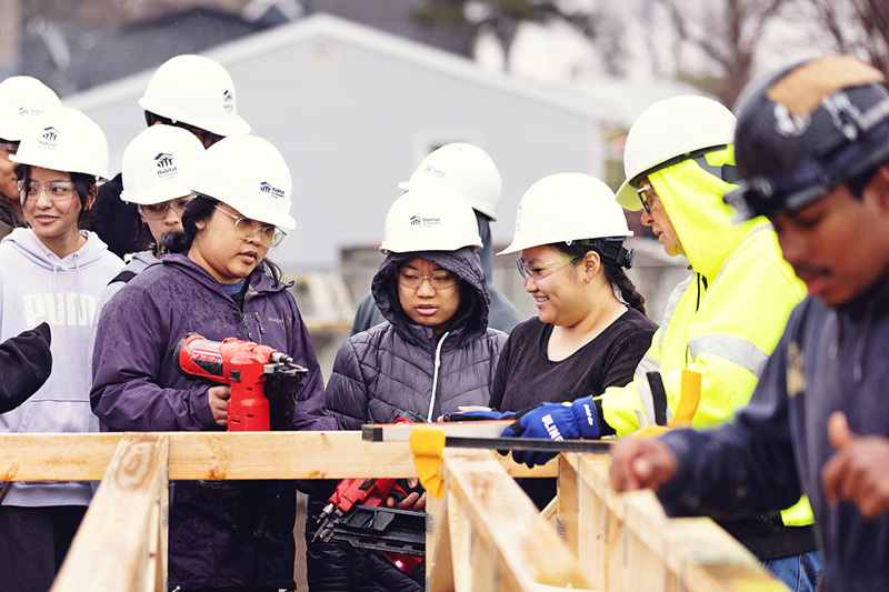 Group of students build frame of house for Habitat for Humanity.
