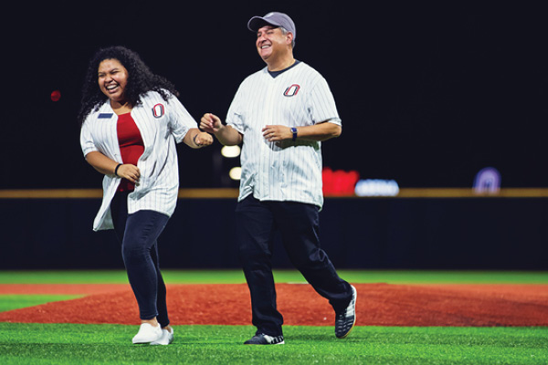 Students pose on the baseball field during a game.