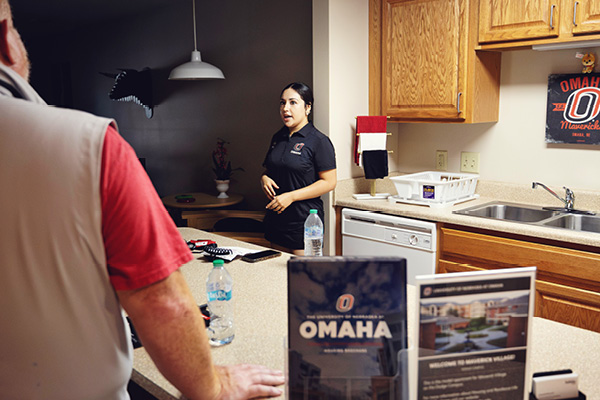 Students gather in a common space near an admissions display.