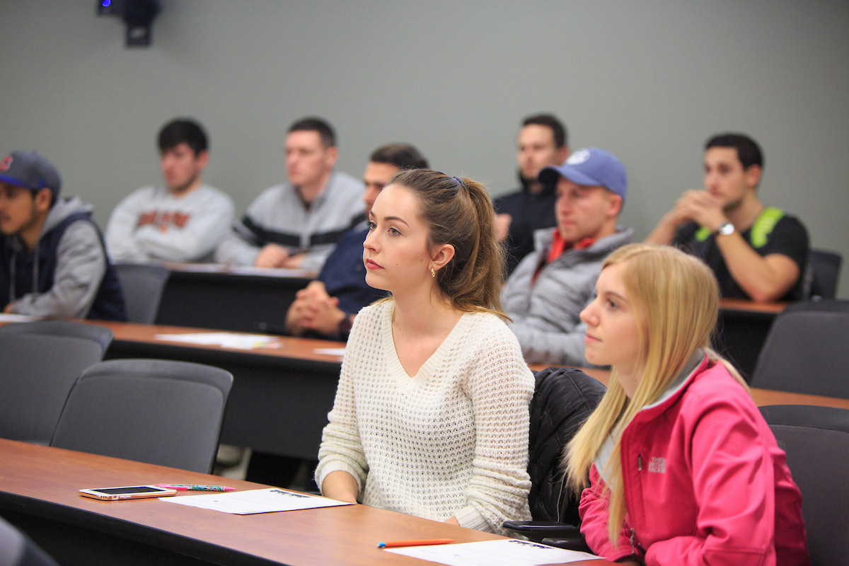 Students sit in a classroom listening to a lecture.