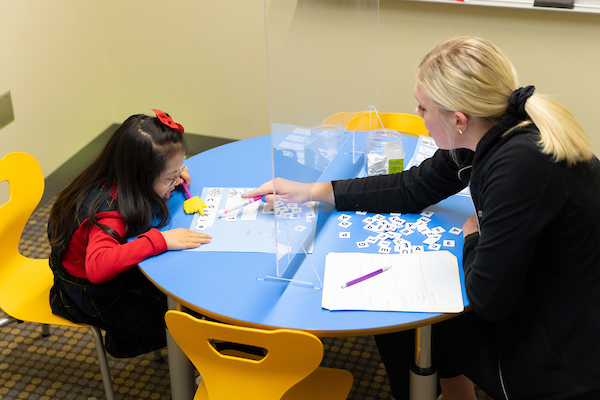 a woman helps a special needs child read