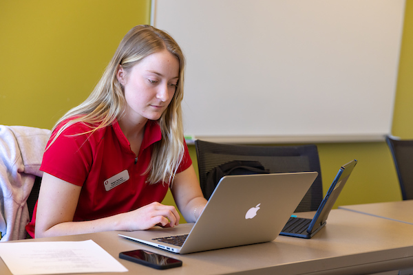 a woman works on a laptop