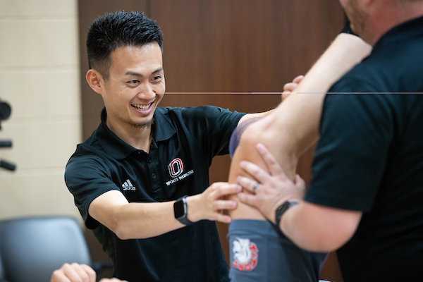 a man helps a patient with is leg