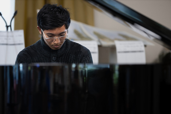 an asian student plays the piano