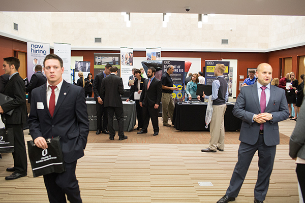 people stand in talk with each other at the cba career fair