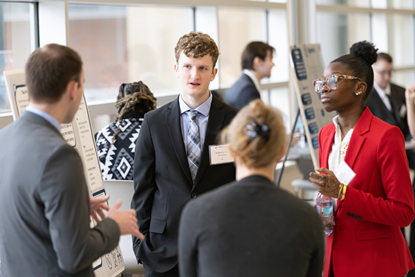 Pair of students in suits presenting information.