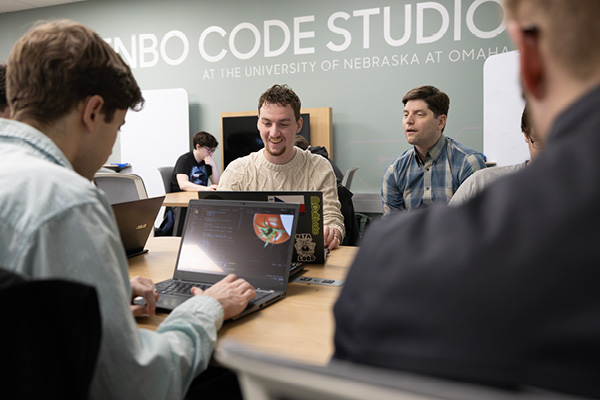 A group of students on their laptops in the code studio.