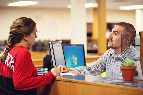 A financial aid counselor meets with a student in an office setting.