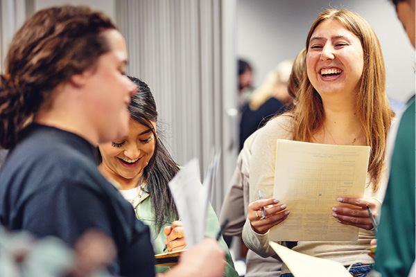 Students laugh while reviewing scholarship information.