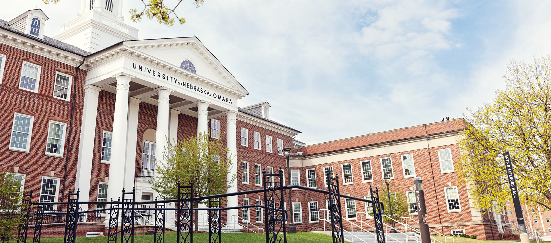The front entrance of a building on UNO's campus on a sunny day.