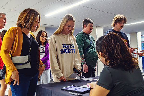 family is greeted at a table for a welcome event
