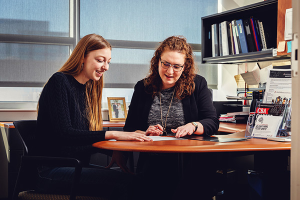 female student works with her advisor in their office