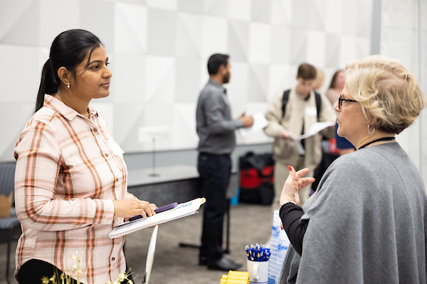 student talking with a representative from a local company