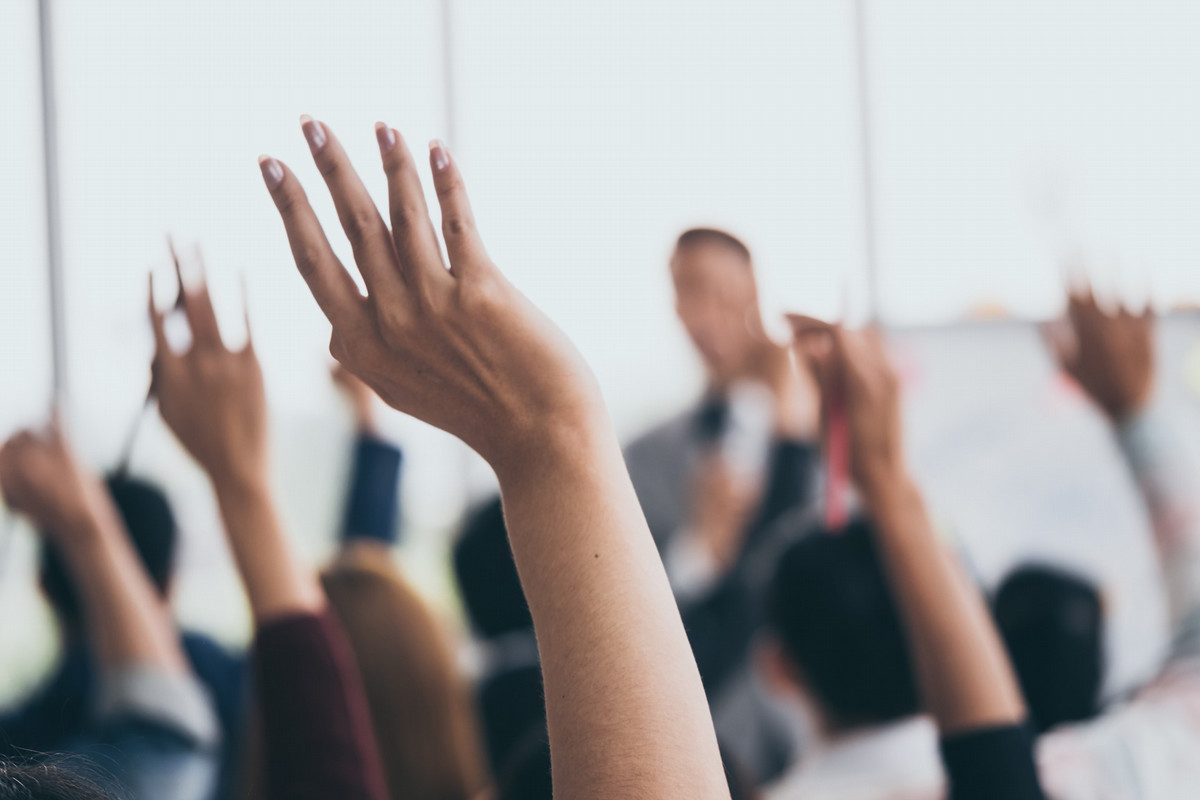 people raising hands in a vote