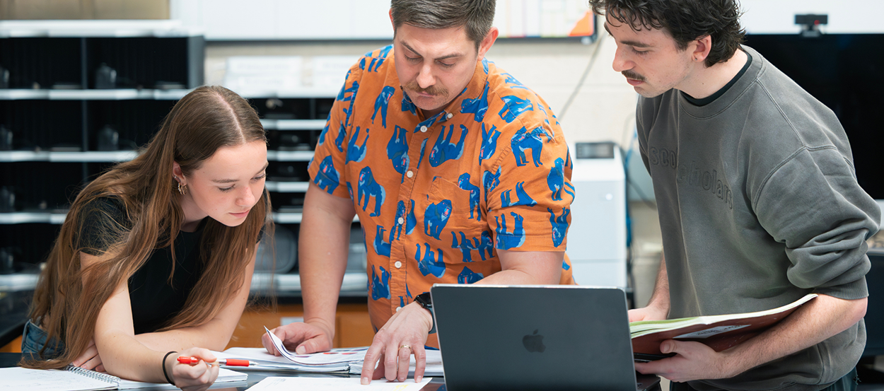 Students work alongside a professor.