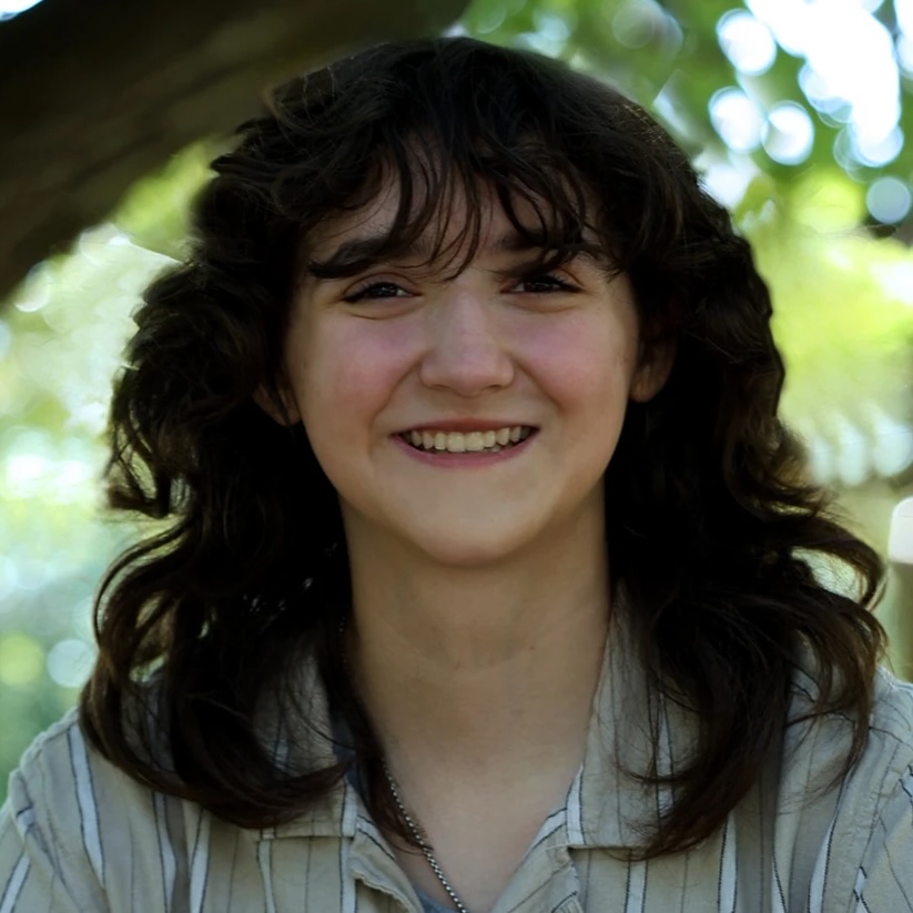 Kenzie Metzler portrait outdoors with trees on the background