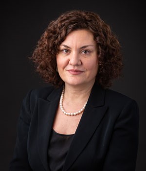 Dr. Lana Obradovic wearing a black camisole and jacket with white pearls