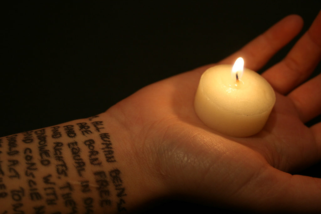 hand with candle and human rights words