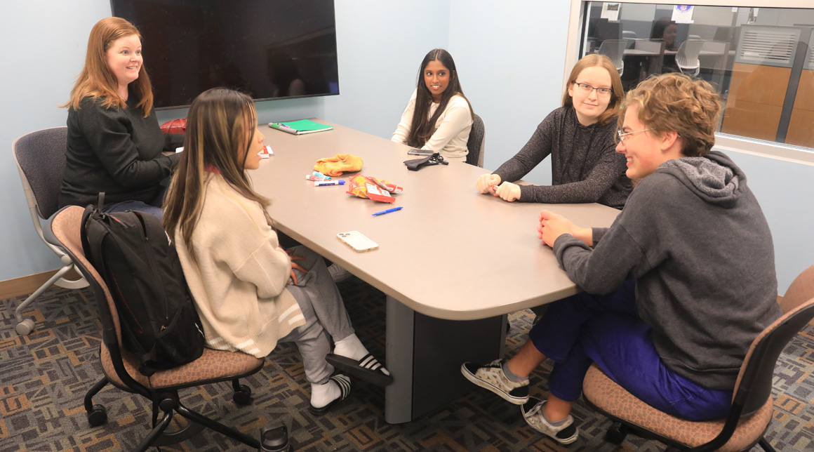 Students sitting around a table and doing math.
