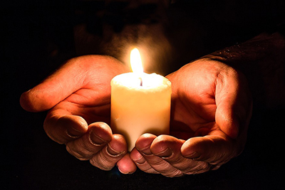 Hands holding candle