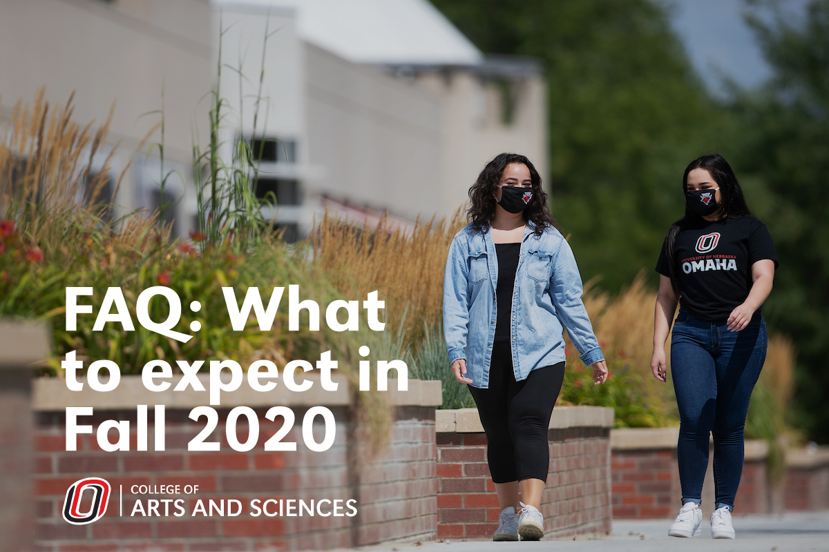 Two female students walking on campus wearing masks