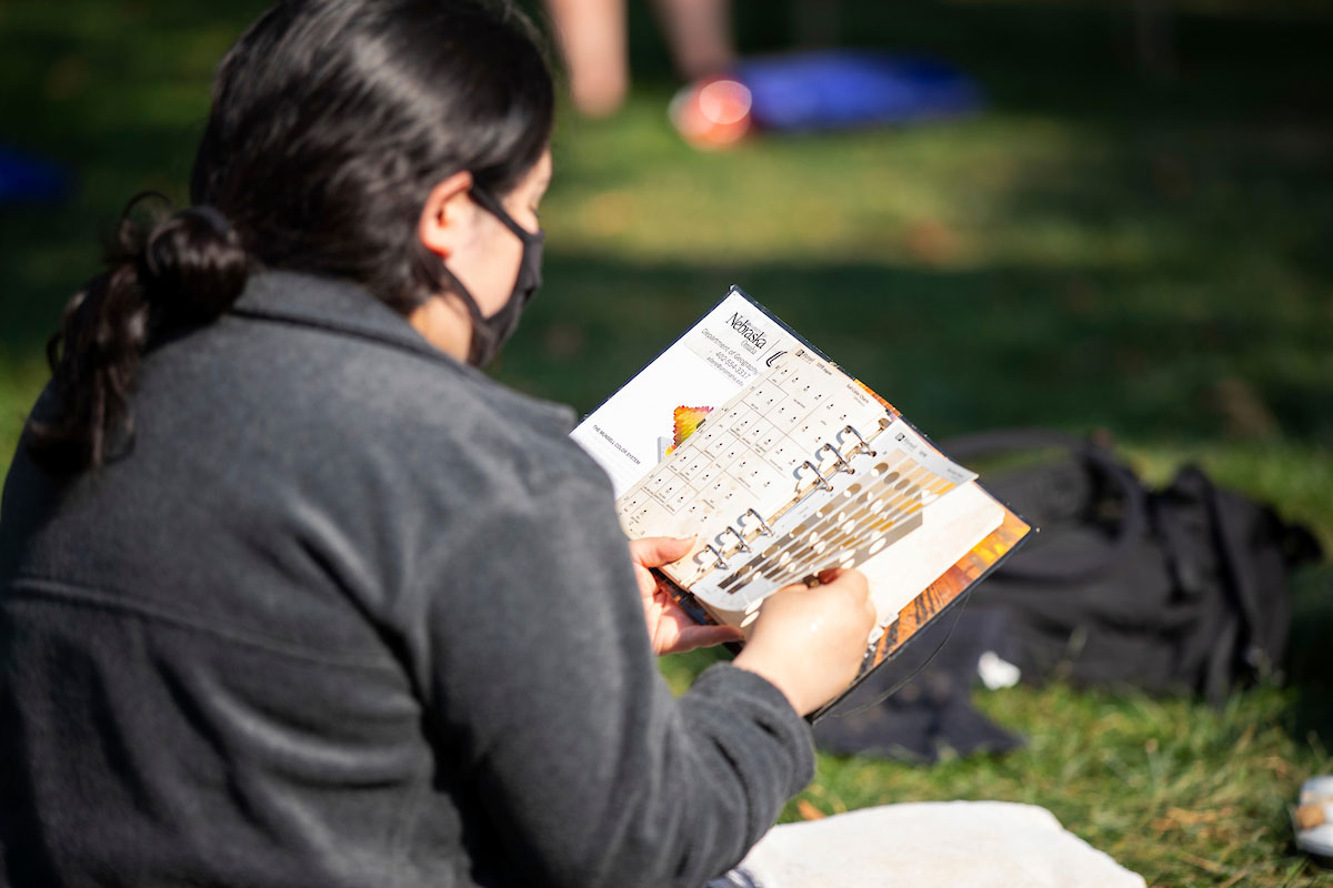 A student looks at a book of soil colors to compare against her sample