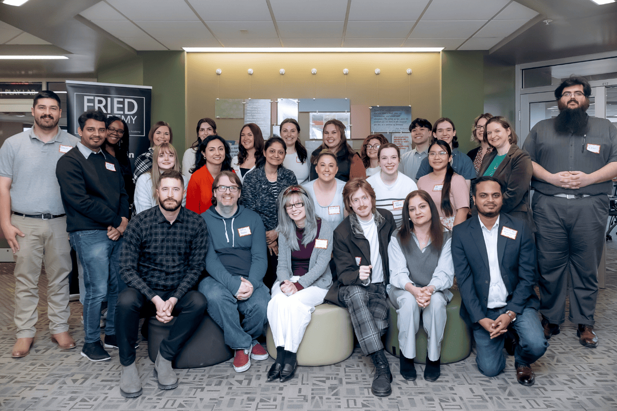 A group of attendees and presenters stand together at the first workshop. 