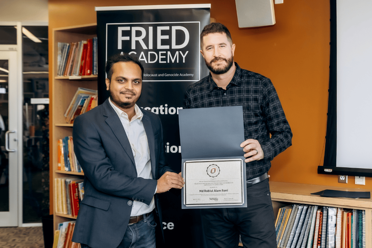 Md Robiul Alam Roni and Mark Celinscak hold a plaque.