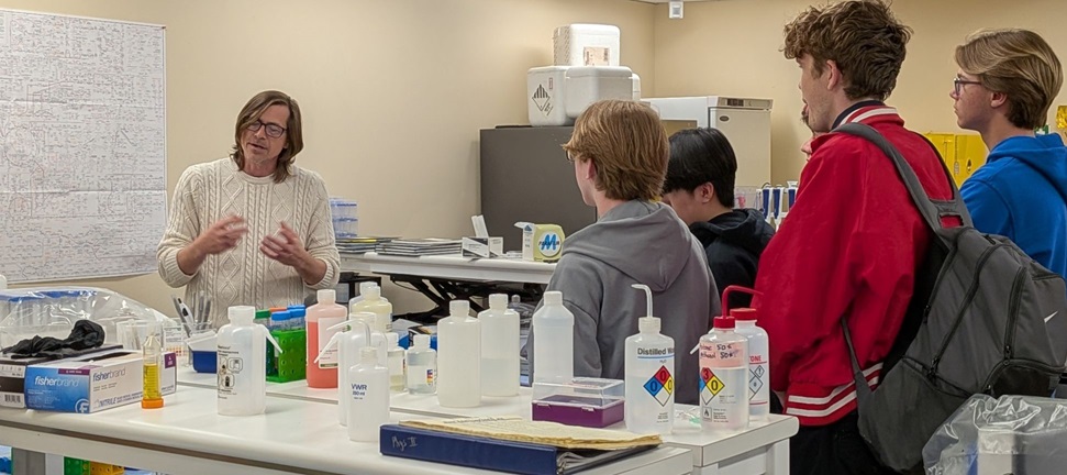 Physics professor showing off his research lab to students