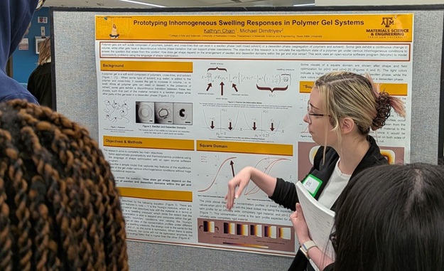 Female physics student discussing her research poster