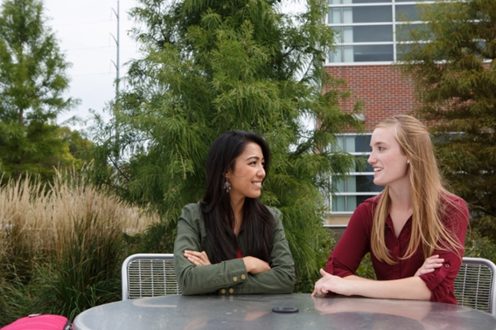 two students chatting at a table