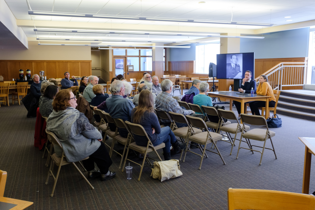 Lecture attendees sit and listen to a speaker at an event. 