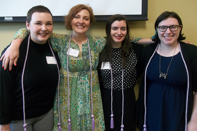 Students wear decorative purple cords.
