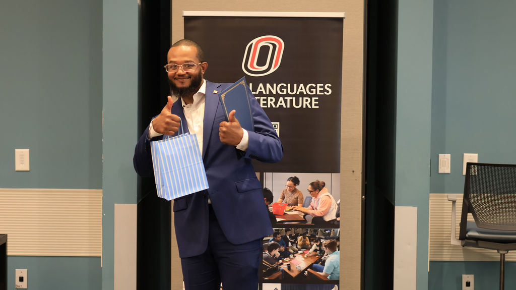 Male student holding gift bag received at award ceremony