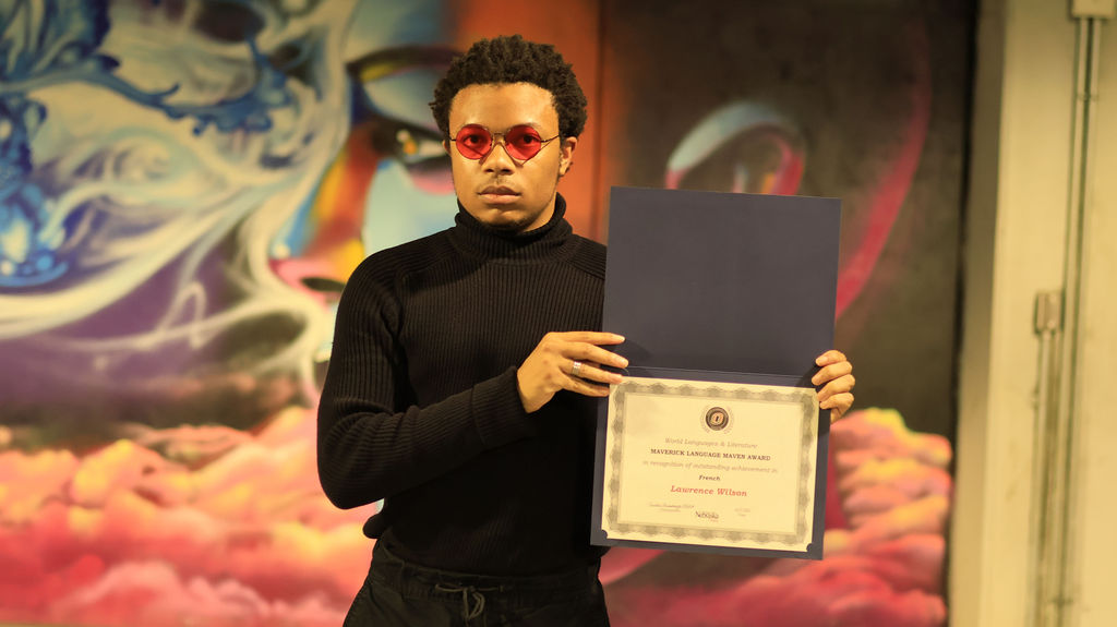 Lawrence Wilson holding his award certificate at the ceremony